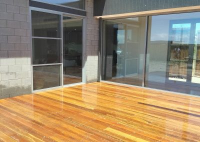 Outdoor deck with timber flooring and glass sliding doors for outdoor living.