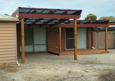 Outdoor patio with wooden pergola and brick wall for outdoor living, ideal for relaxing and entertai.